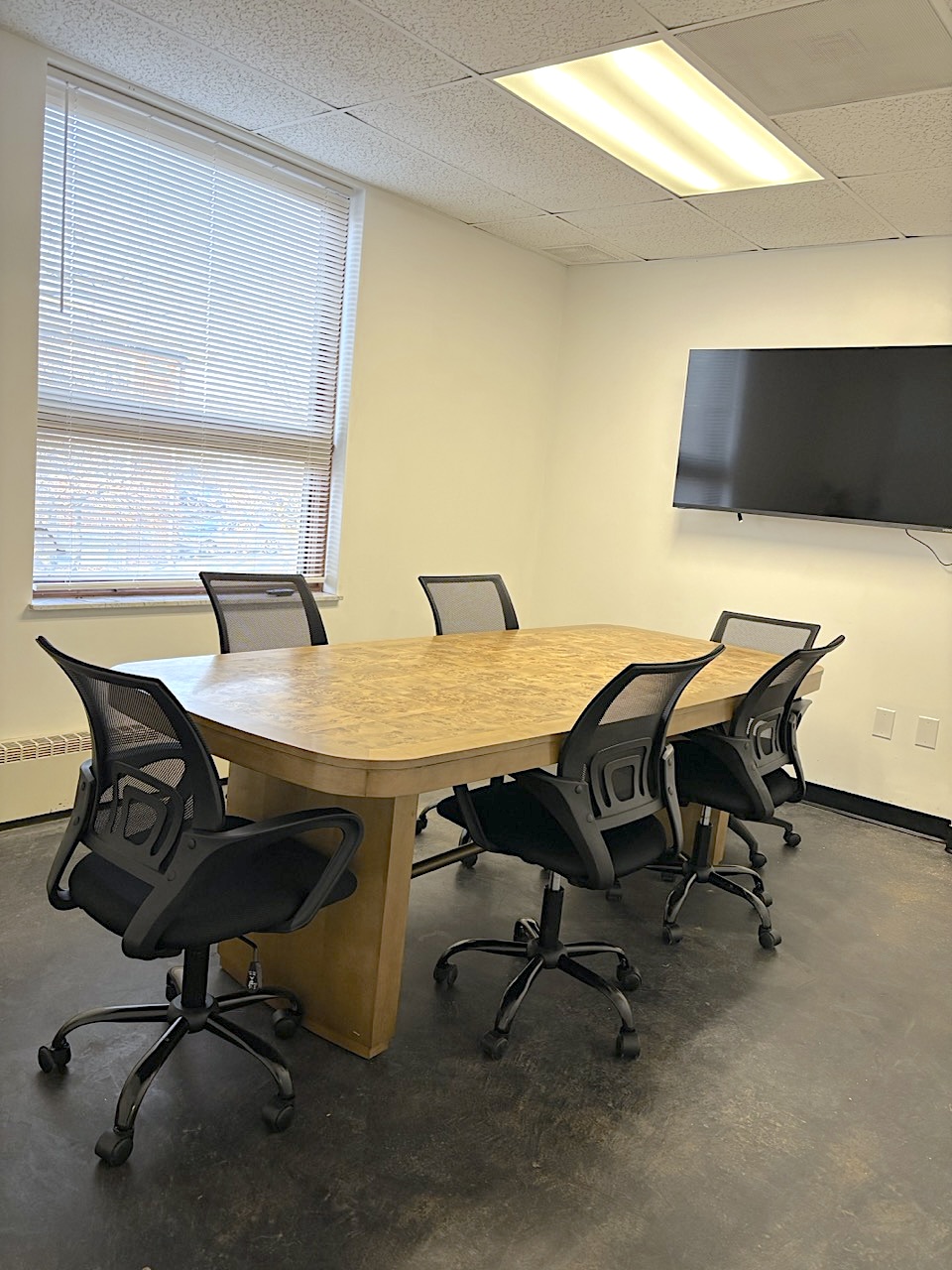 Ren AI Lab conference room with burl wood table and ergonomic chairs